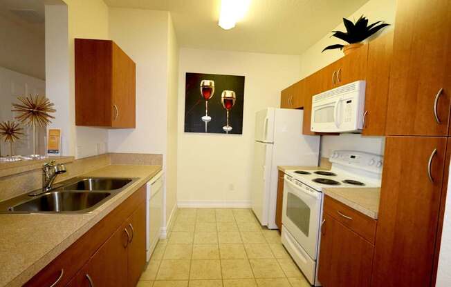 A kitchen with a fridge, microwave, and oven.