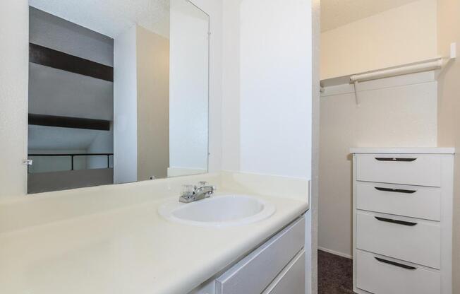 a white sink sitting under a mirror