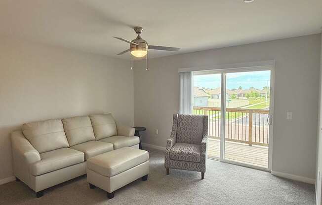 A living room with a couch, chair, and sliding glass doors.