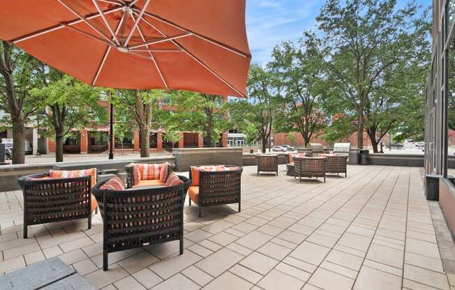 a patio with tables and chairs and an umbrella