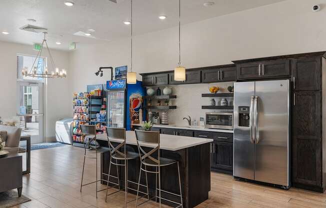 a kitchen with stainless steel appliances and a bar with three stools