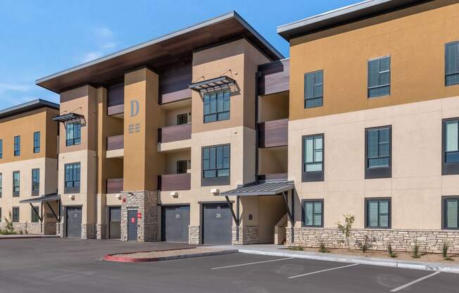 a building with a parking lot in front of itat Solace at Ballpark Village, Goodyear, AZ