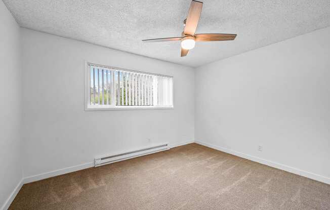 a bedroom with a ceiling fan and a window