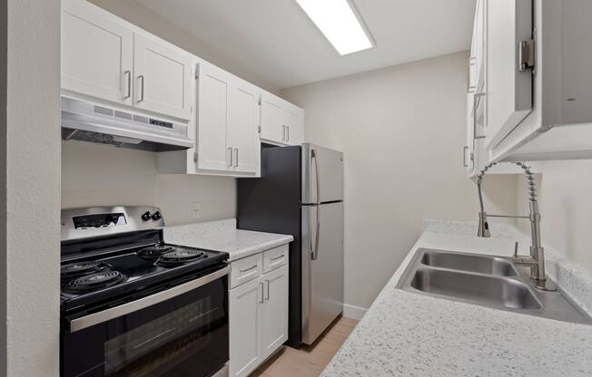 Kitchen with white cabinets and a black stove and refrigerator at Verde Apartments in Tucson, 85719