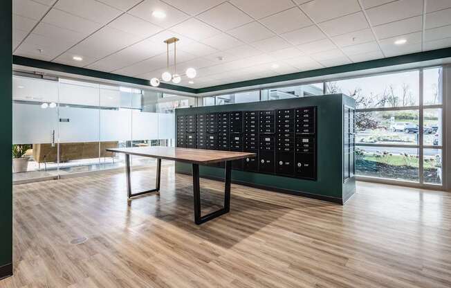 A room with a long table and a black panel on the wall.