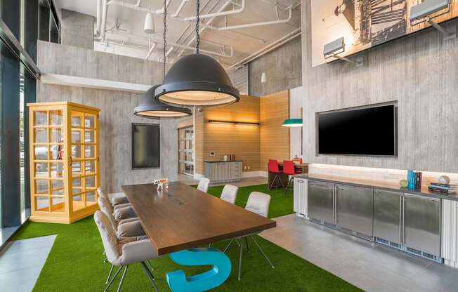 a conference room with a table and chairs and a television