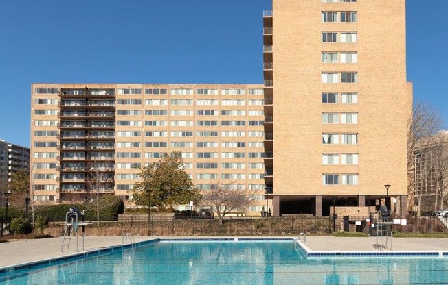 A large building with a pool in front of it.