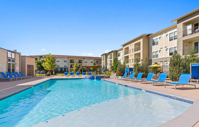 our apartments have a large swimming pool with blue lounge chairs