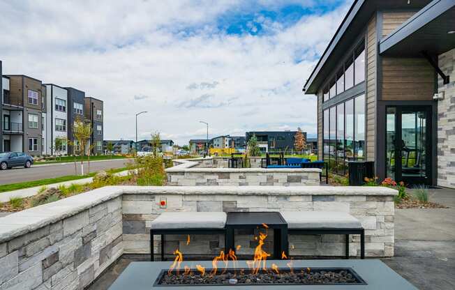 a patio with a fire pit in front of a building