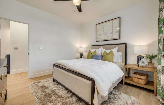 A bedroom with a large bed and a ceiling fan.