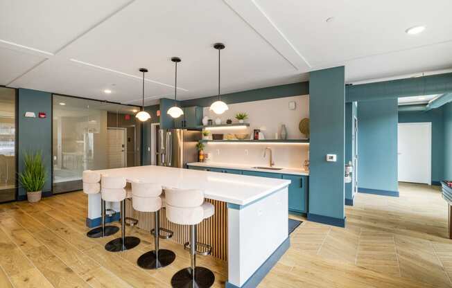 a kitchen with blue walls and a white island with bar stools at EagleRidge Plaza Residences, Fargo, ND