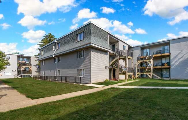 Apartment complex with a grey building and a black fence.