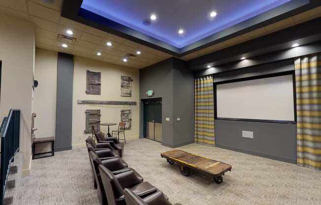 a large screening room with chairs and a projector
