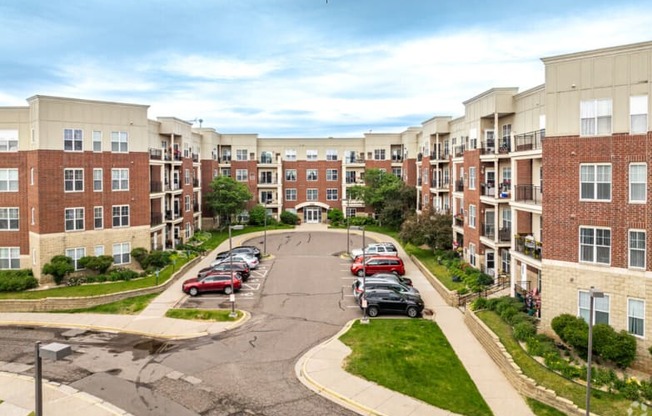 an aerial view of an apartment complex with cars parked on the street