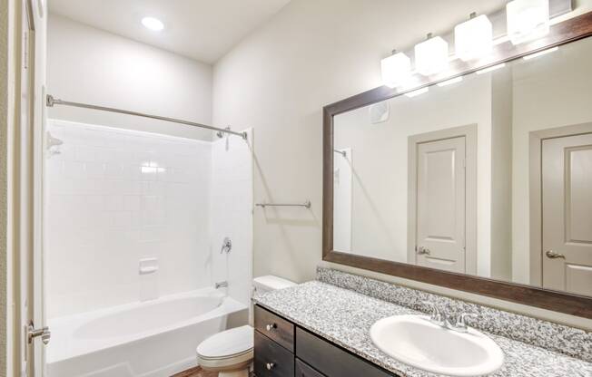 a bathroom with a shower and a sink and a mirror
