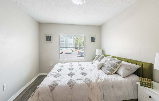 A bedroom with a large bed and a window overlooking a street.