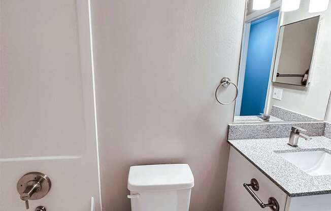 A white toilet sits next to a sink in a bathroom.