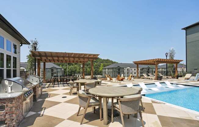 A poolside patio with a table and chairs.