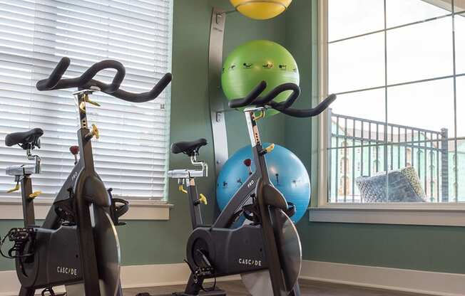a gym with two exercise bikes and an exercise ball