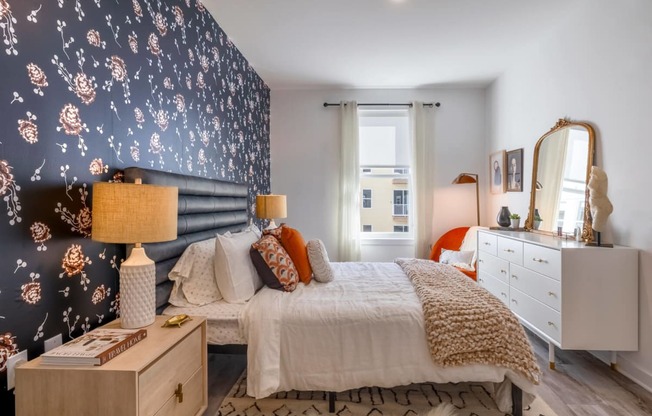 Model bedroom with a bed and blue wallpaper