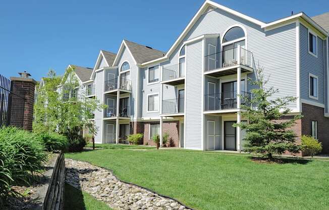A modern apartment building with a well-maintained lawn in front.