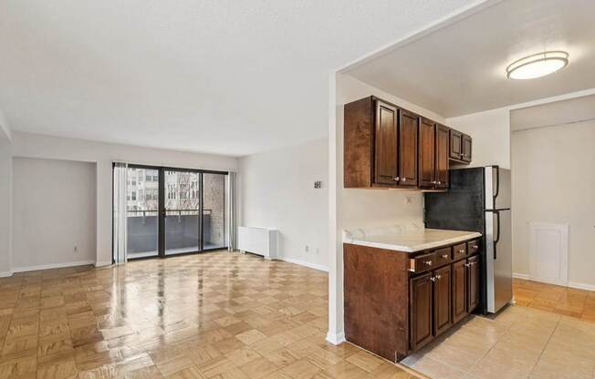 A kitchen with wooden cabinets and a refrigerator.