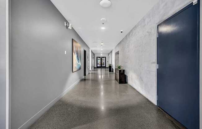 A long hallway with a blue door on the right.