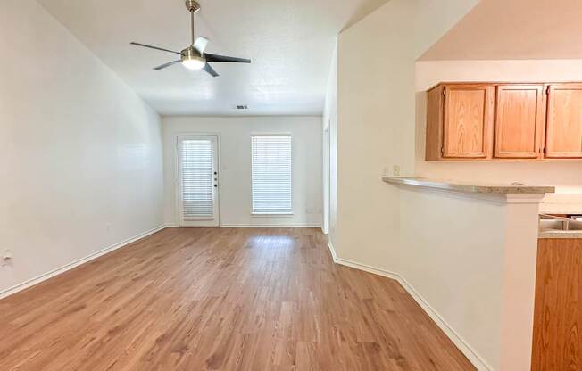 A room with wooden flooring and a ceiling fan.