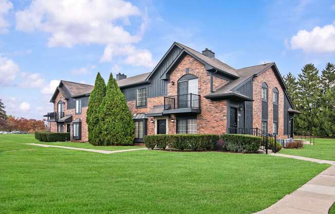 A large house with a black iron fence and a green lawn.