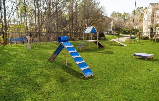 a playground with a slide and benches in a park