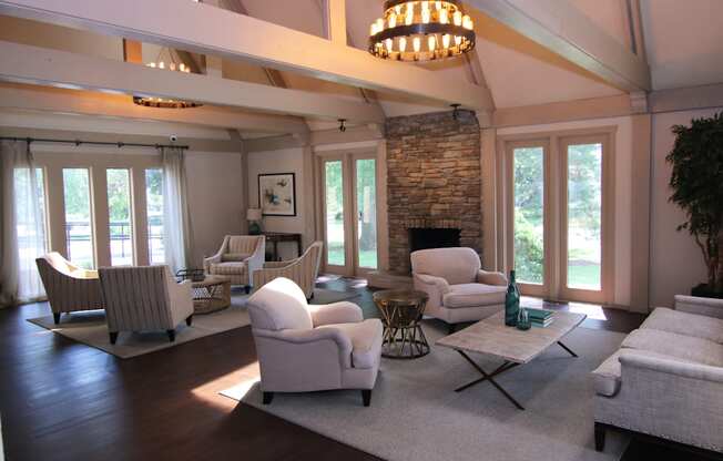 A living room with a stone fireplace and a chandelier.