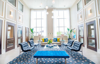 a living room with blue furniture and tall windows