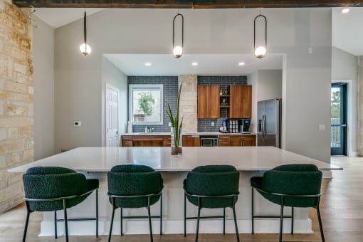 a kitchen with a large white island and green chairs