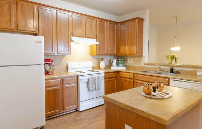 A kitchen with wooden cabinets and a white refrigerator.