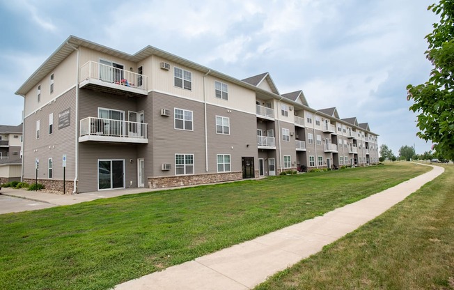 a large apartment complex with a grassy area in front of it