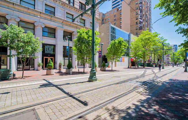 a city street with streetcar tracks and a building in the background