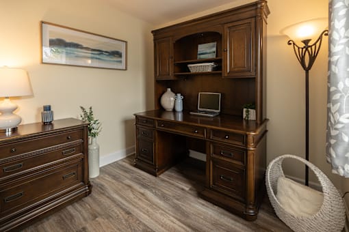 A room with a wooden desk and a chair.