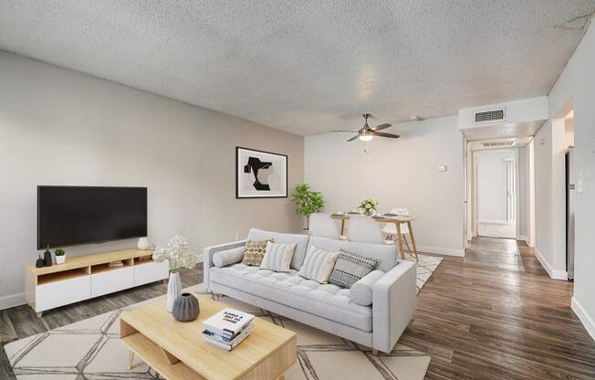 a living room with a couch a coffee table and a tv on the wall