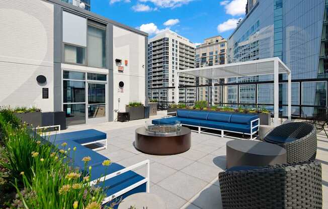 A modern outdoor seating area with a white awning and blue seating.