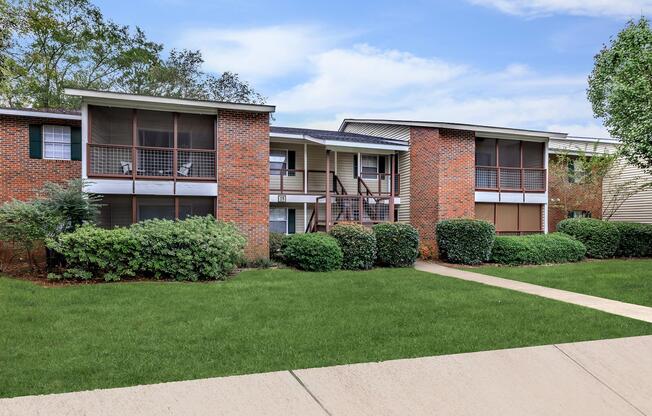 a large brick building with grass in front of a house