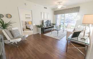 A living room with a white chair and a glass table.