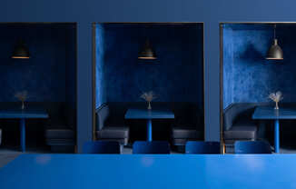 a blue restaurant with tables and chairs and blue lighting