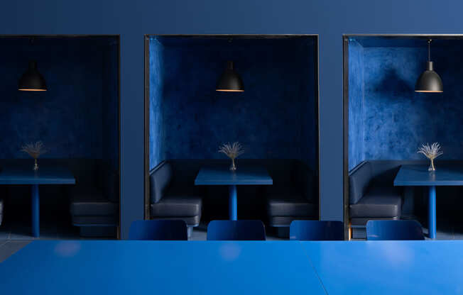 a blue restaurant with tables and chairs and blue lighting