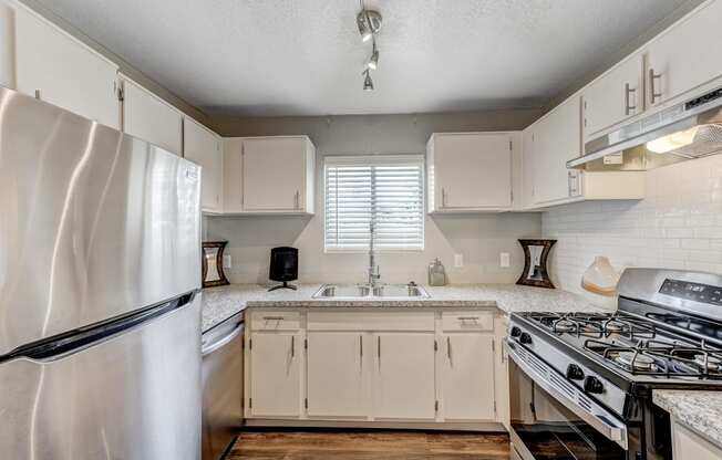 an updated kitchen with white cabinets and stainless steel appliances at Desert Bay Apartments, Laughlin, NV, 89029