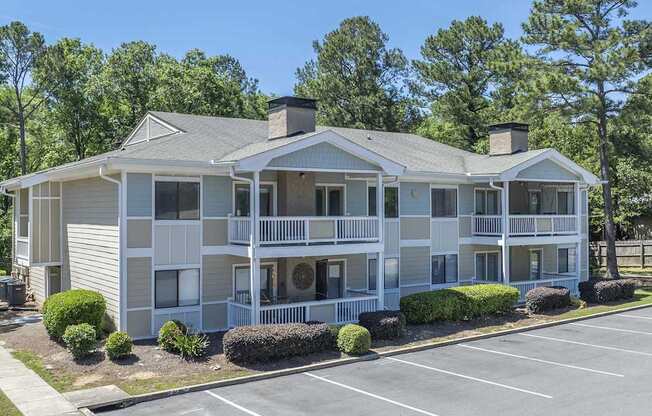 A two-story building with a parking lot in front.