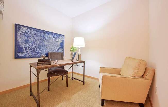 A room with two chairs, a desk, and a painting on the wall.