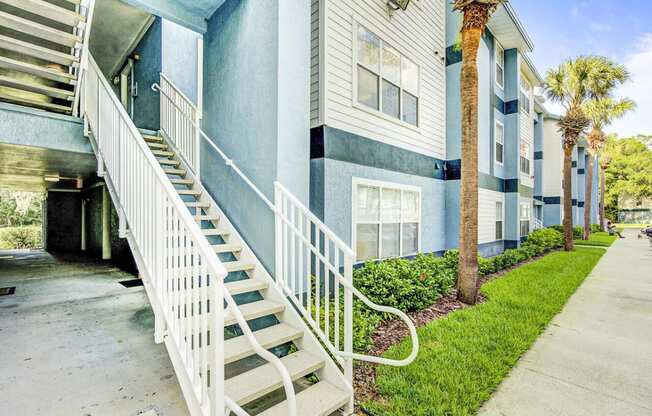 Apartment Building Exterior and Stairway Next to Grass and Decorative Plants