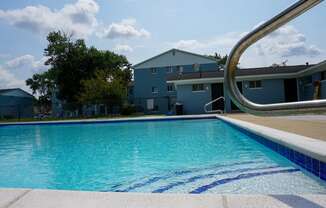 Swimming Pool Entry with pool chairs and apartment building, at Gale Gardens