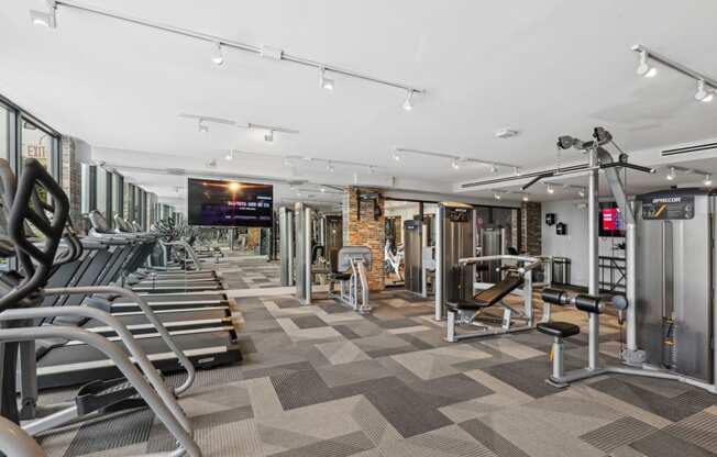 a gym with cardio equipment and weights on a checkered floor