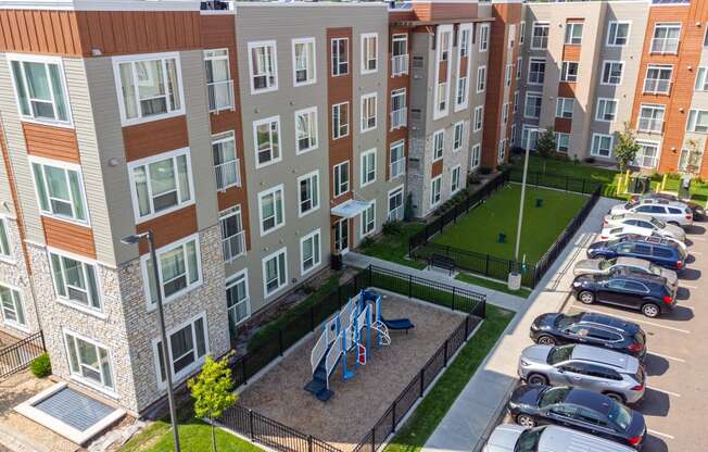 an aerial view of an apartment building with cars parked in a parking lot